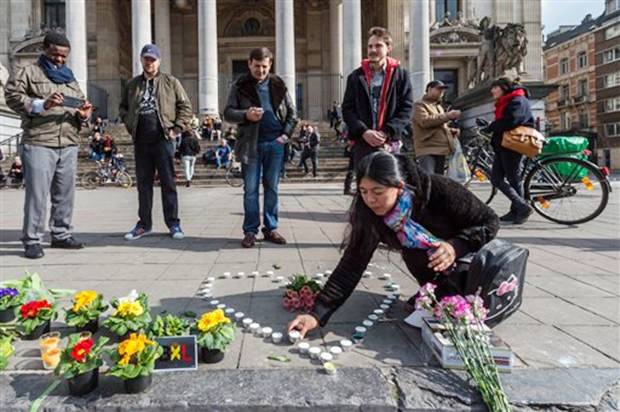 Während die Suche nach dem flüchtigen Terroristen weitergeht, legen Menschen auf dem Schauplatz des grausigen Geschehens Blumen nieder. Während die Suche nach dem flüchtigen Terroristen weitergeht, legen Menschen auf dem Schauplatz des grausigen Geschehens Blumen nieder.