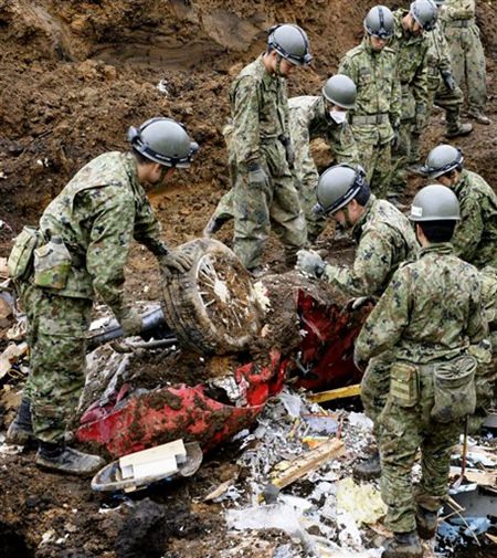 Soldaten graben ein Auto aus den Erdmassen, da durch das Beben ein starker Erdrutsch entstanden war. (Takuya Inaba/Kyodo News via AP) Soldaten graben ein Auto aus den Erdmassen, da durch das Beben ein starker Erdrutsch entstanden war. (Takuya Inaba/Kyodo News via AP)