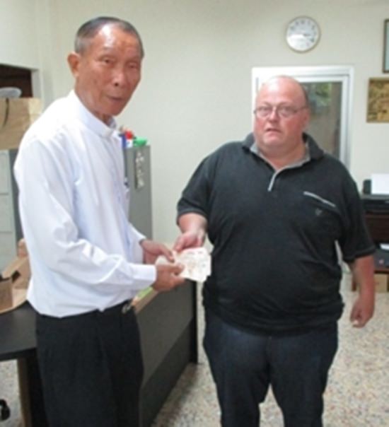 Martin Jahraus (rechts) übergibt 5.500 Baht an Vater Michael Weera.