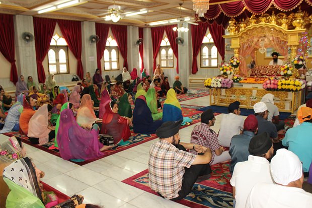 Die Sikh Gläubigen beten vor den Guru Granth Sahib, der Heiligen Schrift der Sikhs. 