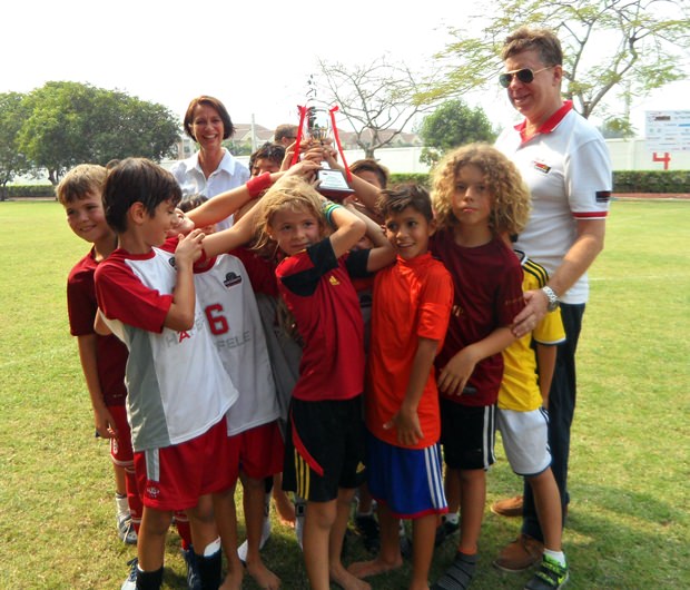 Die Schweizer Botschafterin Christine Schraner-Burgener (im Hintergrund) mit dem siegreichen Kinderteam nach der Übergabe des Pokals. 