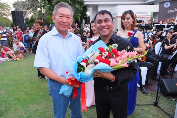 Dr. Pornthep Phornprapha, der Präsident von Siam Motors Co. (links) überreicht Blumen an den Dirigenten, Oberstleutnant Prateep Suphanrojn. 