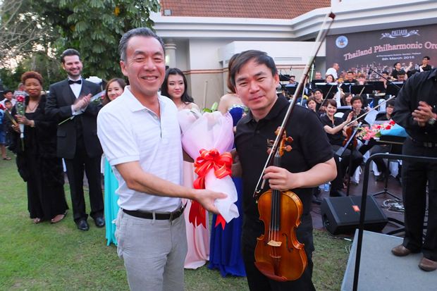 Masaya Furuta, Vizepräsident von Yamaha (links) schenkt dem Konzertmeister Sittichai Pengcharoen ebenfalls Blumen.