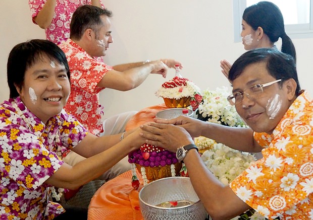 Die Angestellten ehren die Älteren indem sie ihnen Blütenwasser über die Hände gießen. 