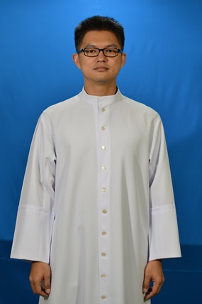 Vater John in offizieller Pose als Priester.