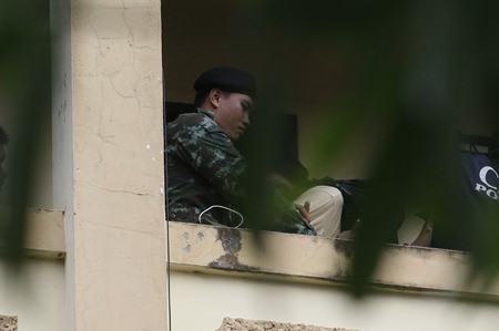 Ein Soldat führt einen Verdächtigen mit einem Sack auf dem Kopf aus dem Apartment. (AP Foto/Sakchi Lalit)