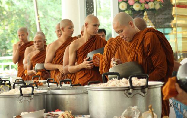 Mönche im Wat Pa Suthipawan Naklua „Chan“ essen das von Gläubigen mitgebrachte Mahl.