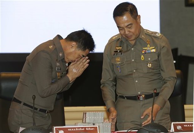 Polizeichef Somyot Poomphanmuang, rechts, überreicht an seinen Stellvertreter Jakthip Chaijinda, 3 Millionen Baht Bargeld für die Verhaftung von Verdächtigen. Jakthip nimmt das Geld in Vertretung der Polizeikräfte entgegen. (AP Photo/Sakchai Lalit)