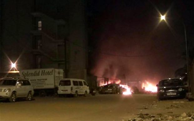 Die Lobby des Hotels steht in hellen Flammen, während Sicherheitsbeamte die geretteten Geiseln in Sicherheit bringen. (AP Television) Die Lobby des Hotels steht in hellen Flammen, während Sicherheitsbeamte die geretteten Geiseln in Sicherheit bringen. (AP Television)