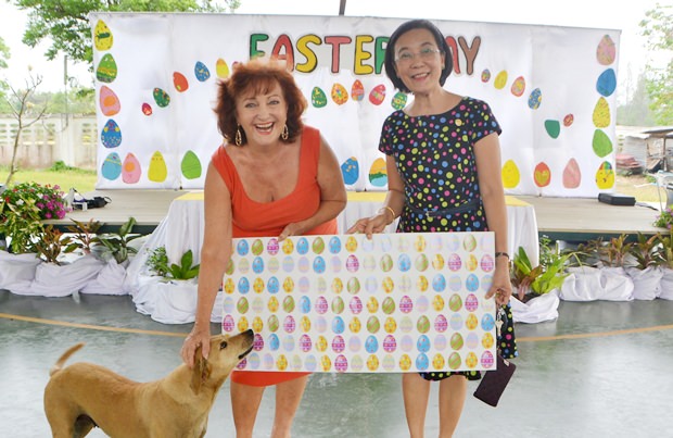 Radchada Chomjinda und Elfi Seitz begrüßen die Kinder und die Gäste und zeigen das Plakat mit den Ostereier-Losnummern. Hund Geo ist wie immer bei Elfi mit dabei obwohl er zum Center gehört. 