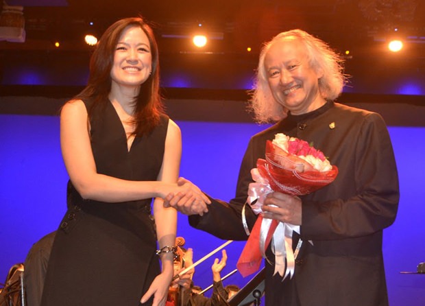Alisa Phanthusak (links), die Assistenz-geschäftsführende Direktorin der Tiffany’s Show Pattaya, überreicht dem Dirigenten, dem Japaner Hikotaro Yazaki, einen Blumenstrauß.