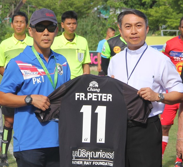 Vater Peter Pattarapong Sriworakul, der Präsident der Father Ray Stiftung, erhält eine Fußballtrikot von Poonpol Kamuttira. 