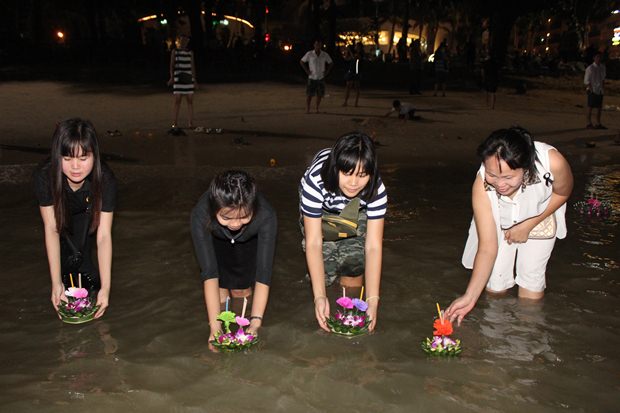 Familien lassen ihre Krathongs gemeinsam zu Wasser am Pattaya Strand. 