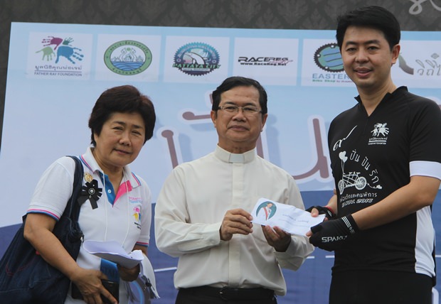 Poramet Ngampichet überreicht eine Spende an Vater Michael und Khun Ajima, die Event Organisatoren. 