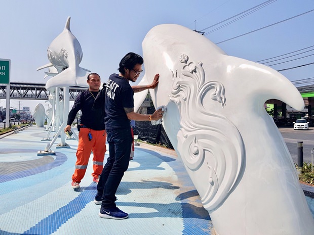 Arbeiter entfernen die aufgesprühte Farbe von Pattayas Wahrzeichen.