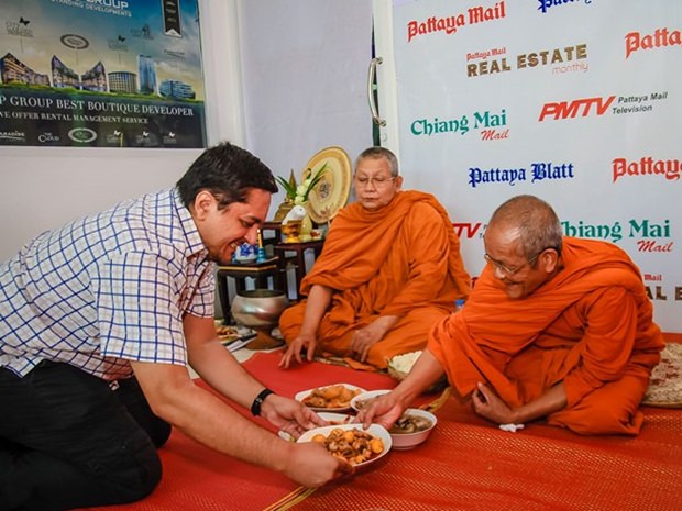 Prince Malhotra, der stellvertretende MD reicht den Mönchen nach den Gebeten das Essen. 