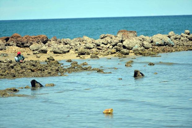 Zuständige Beamte untersuchen die Abflussrohre die am Wongamat Strand ins Meer führen.