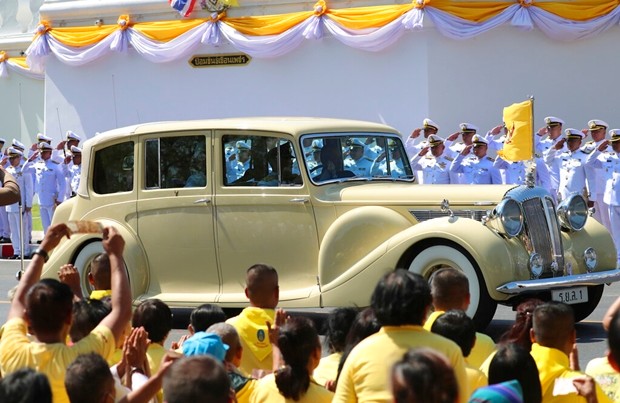 Ihre Majestäten, König Maha Vajiralongkorn und Königin Suthida fahren am Samstag durch Bangkok und werden von ZXuschauern bejubelt. (AP Photo/Sakchai Lalit)