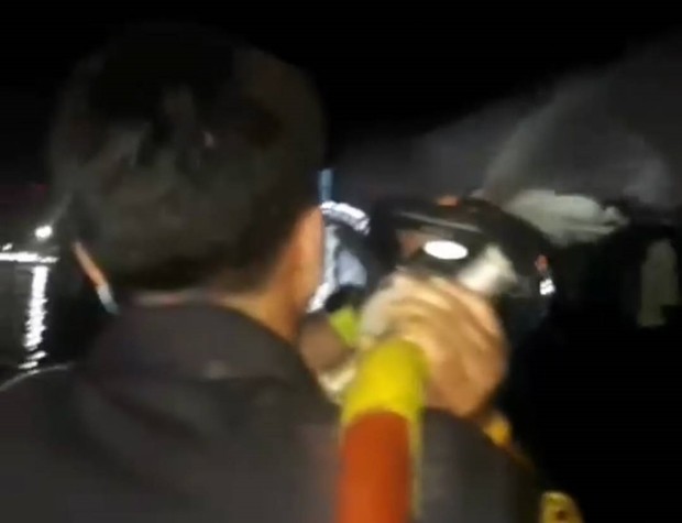 Feuerwehrleute bekämpfen das Feuer an Bord des Schiffes, von dem die Feuerwerksraketen abgefeuert worden waren.