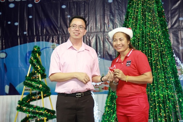 Der ehemalige Pastor Pattayas, Vater Kritsada Sukapat, übergibt einem glücklichen Gewinner eine Goldkette.