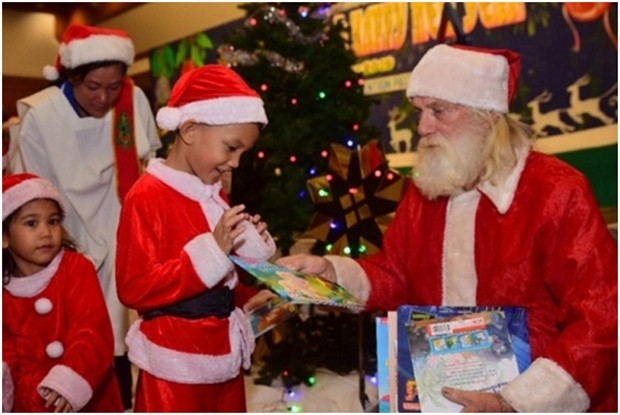 Santa Claus verteilt Geschenke an die Kinder des Waisenhauses. 