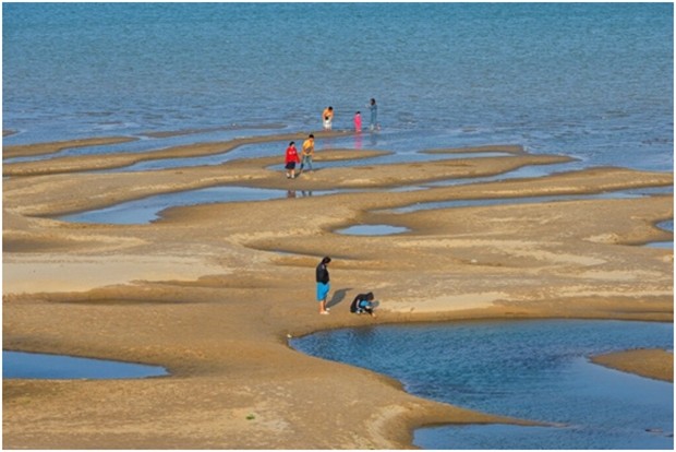 Touristen spielen auf Sandbänken mitten im Fluss. Ein Phänomen, das es bisher nicht gab. (AP Photo/Chessadaporn Buasai) 