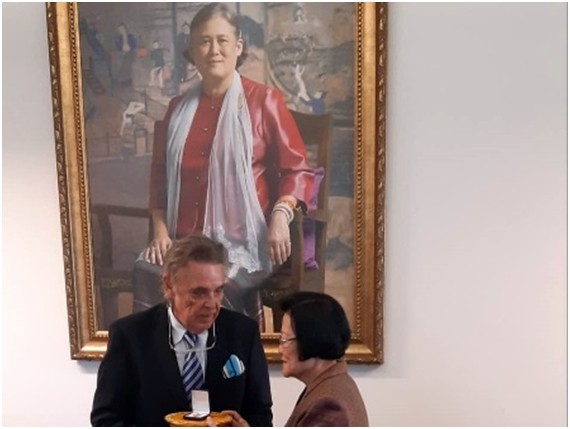 Axel Brauer erhält die Ehrennadel von Assoc. Prof. Khunying Sumonta Promboon, unter dem Bildnis Ihrer Königlichen Hoheit, Prinzessin Maha Chakri Sirindhorn.
