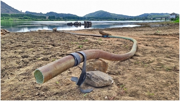 Einwohner pumpen Wasser vom Reservoir in Schläuchen ab. Die Frage ist nun, wie lange wird es dauern bis alles leer ist. 