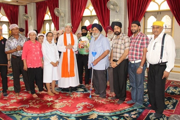 Amrik Singh begrüßt Vater Francis Xavier Kridsada Sukapat, den damaligen Pastor der St. Nikolas Kirche, und seine Begleiter zur Guru Gobind Singh Ji Gurpurab Feier am 28. Dezember 2014.