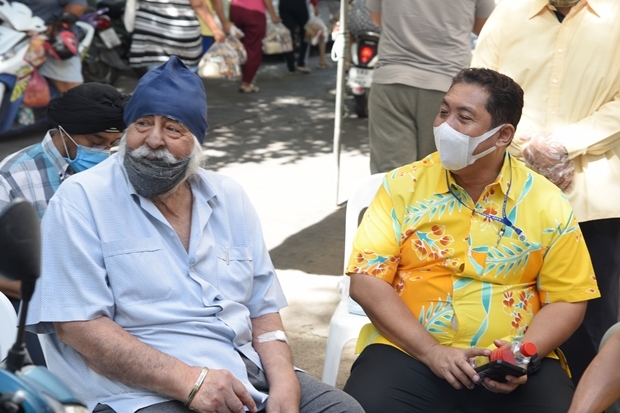 Amrik Singh sitzt gemeinsam mit Bürgermeister Sonthaya Khunplome während Essen an Arbeitslose am 8. Juni 2020 verteilt wird. Die war die letzte Wohltätigkeit an der Amrik beteiligt war.