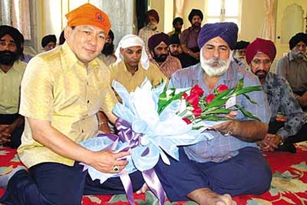 Amriks alter Freund, Chanyuth Hengtrakul, überreicht ihm ein Blumenbouquet zu einer Feier. 